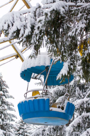 Amusement park. The first snow. Empty cabin from the Ferris wheel covered with snow. No people.の写真素材