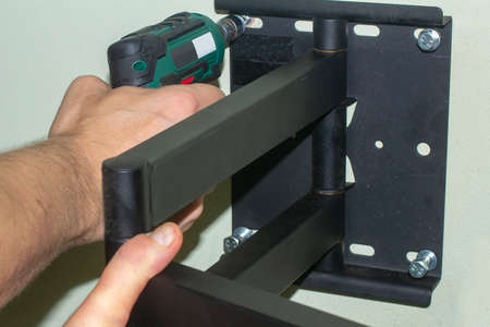 Attaching of the Mount to the Wall. Tightening the bolt by a Cordless Electric Screwdriver.