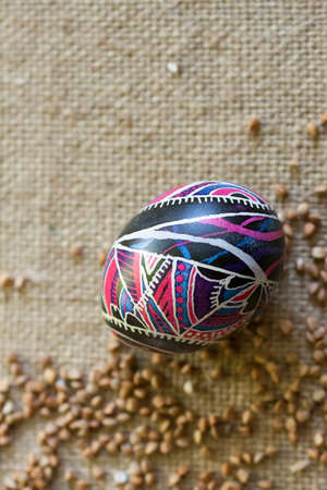 Easter egg with folklore ornament on canvas with buckwheat.の写真素材