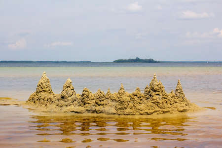 Sand castle in lake water