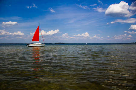 Small ship with red sailの写真素材