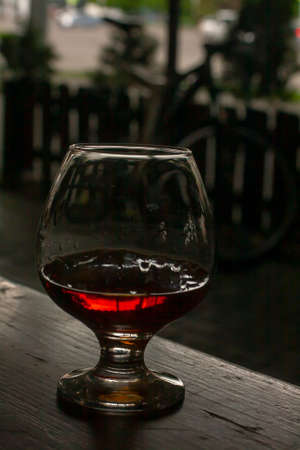 Cognac glass or snifter with cognac on the background of a greased bicycleの写真素材