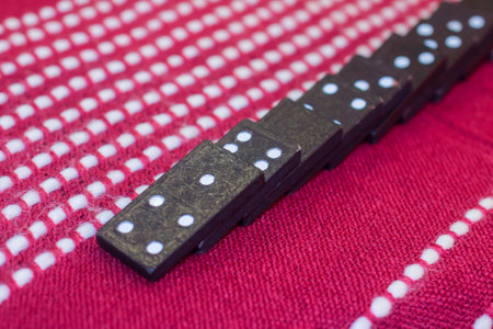 A row of stacked dominoes on a red draperyの写真素材