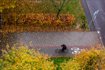 An old man rides an old bicycle along a cycle path on an autumn day. Aerial surveyの写真素材