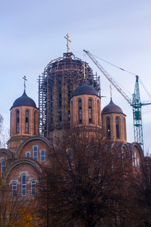 A crane at the construction site of an Orthodox cathedral in Ukraine. vertical photoの写真素材