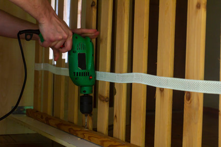 Man making a hole in wood with a drillの写真素材
