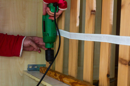 Man repairing furniture at home with a puncherの写真素材