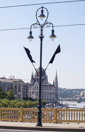 Budapest, Hungary â June 11, 2019; Image of a pillar with black flags and the Parliament from Margaret bridge. Sunken Hableany tour ship raising action to the surface.のeditorial素材