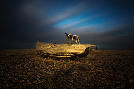 Wrecked ship in sunset at Dungeness beach, England, UKの写真素材