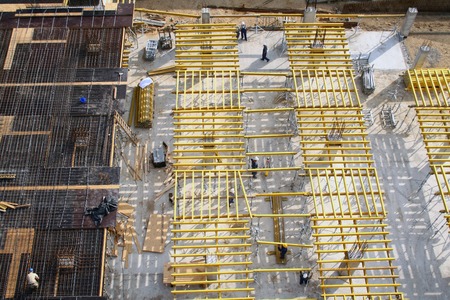 Bird's eye view at construction site where workers are preparing boards for ceiling