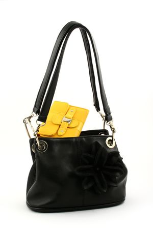 Black handbag with handles up and yellow wallet on a white backgroundの写真素材