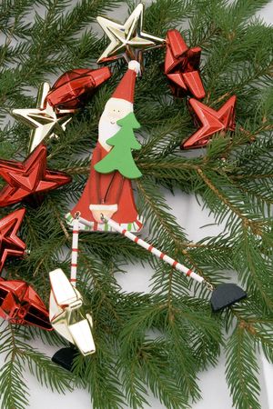 Wooden santa with stars decoration on a fresh spruceの写真素材