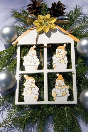 White wooden house witch four snowmen together with christmas decorationの写真素材