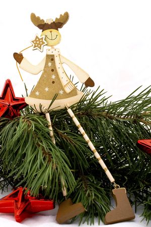Wooden moose sitting on a pine branch on a whiteの写真素材