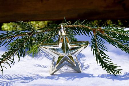 Silver christmas star with little branch on a white の写真素材