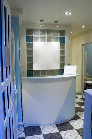 View at reception desk in a spa centre with white board hanging on a wall and empty price-listの写真素材