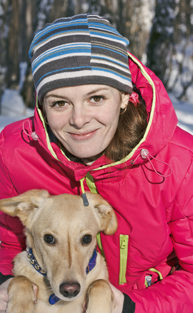 Portrait of girl with dog in winter Park close-up.の写真素材