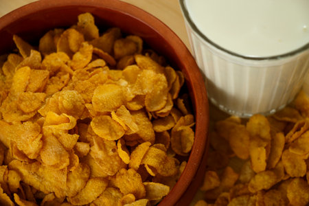 A bowl of cornflakes and a glass of milk on the kitchen board high-angle shot close up Black Backgroundの写真素材