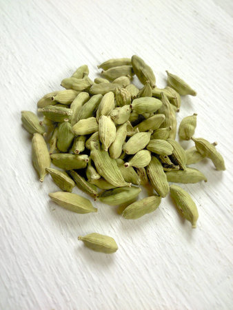Cardamom seeds on white table.の素材