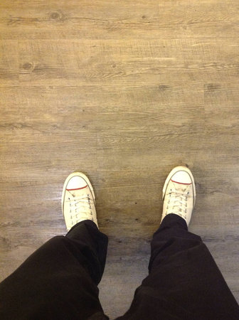 A pair of male legs stepping on wooden floorの素材