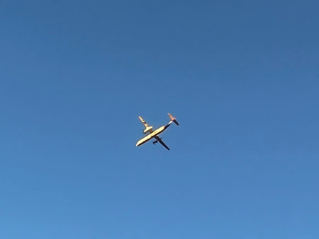 Small airplane flying in the blue sky with white clouds on a sunny day