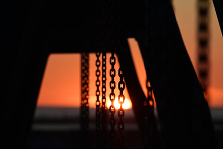 Silhouette of a chain on the bridge at sunset. Selective focus.の写真素材