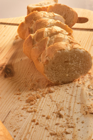 Bread slices on a wooden board with crumbs around
