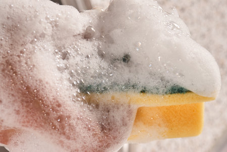 Foam covered scourer over a sinkの写真素材