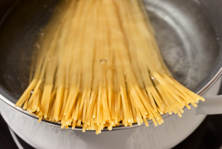 cooking spaghetti in a pot of boiling waterの写真素材