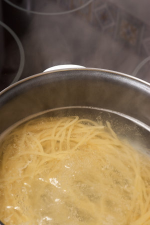 cooking spaghetti in a pot of boiling waterの写真素材