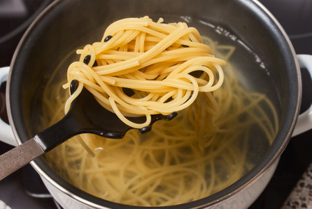 cooking spaghetti in a pot of boiling waterの写真素材