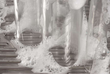 several soap covered glasses in a sinkの写真素材