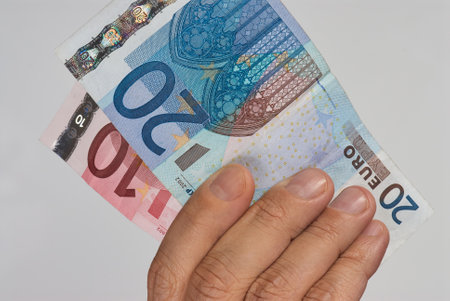 Hand picking up euro billsの写真素材