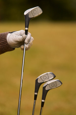 Gloved hand holding golf clubの写真素材