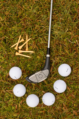 Detail of six balls and golf club on the grassの写真素材