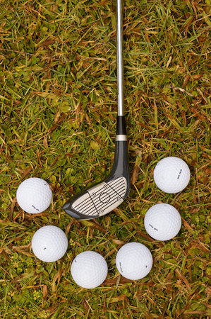 Detail of six balls and golf club on the grassの写真素材