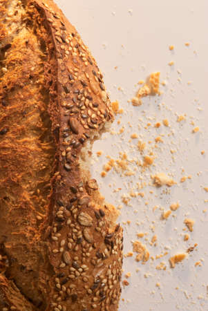 Bitten and cut bread with crumbs aroundの写真素材
