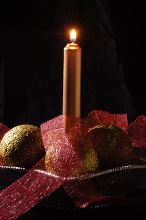 Lit candle and christmas ballsの写真素材