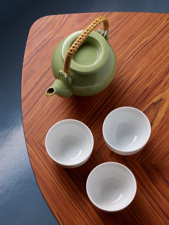 Set of porcelain teapot and cups on wooden tableの写真素材