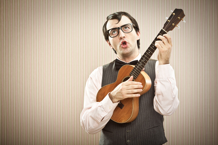 Nerd man with glasses play ukuleleの写真素材