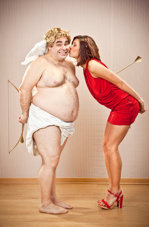 happy shy cupid kiss by beautiful love woman for valentine dayの写真素材