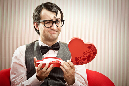 Happy nerd man open chocolate box love giftの写真素材
