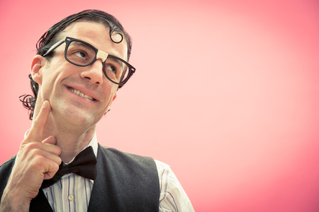 Happy man with nerd glasses portrait on pink thinkの写真素材