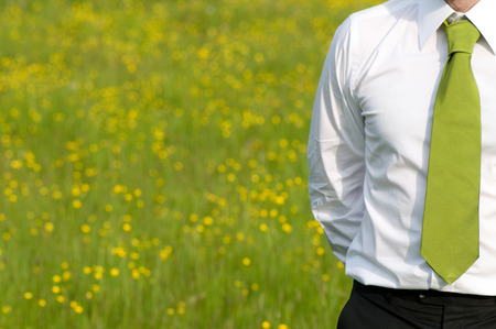 businessman with green tie standing in countrysideの写真素材