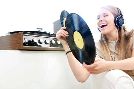 Young beautiful woman listen music with record in a living room