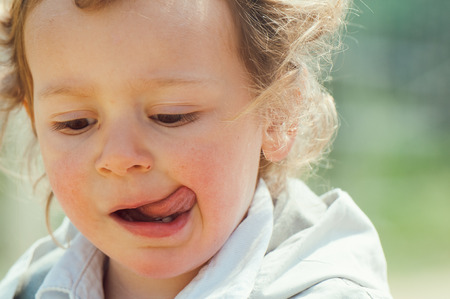 beautiful blond curly hair child play outdoor in a parkの写真素材