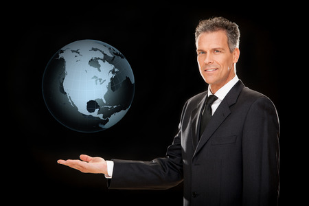 handsome elegant businessman hold a world isolated on blackの写真素材