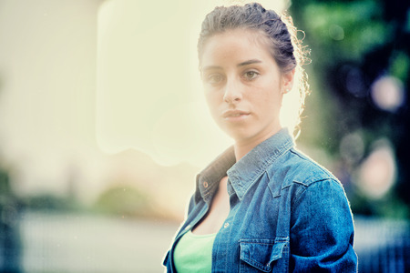 Beautiful curly girl portrait at sunset in a gardenの写真素材