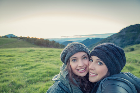 Young women looking at camera hug themselves in nature outdoorの写真素材