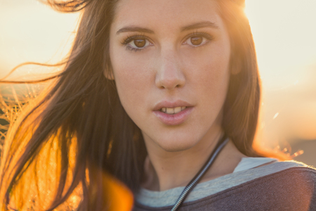 Young smiling brunette hair woman portrait on sunset in natureの写真素材